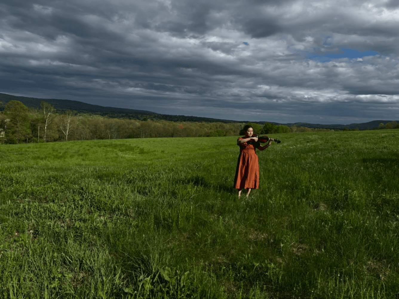 Charlotte at Amherst Book & Plow Farm, playing viola in the meadow 